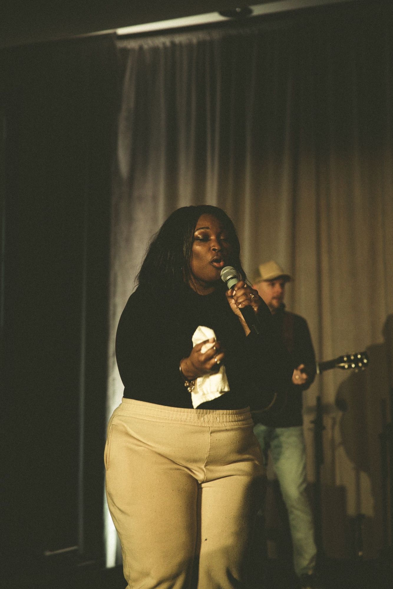 Lou Taylor singing on stage with a guitarist behind her